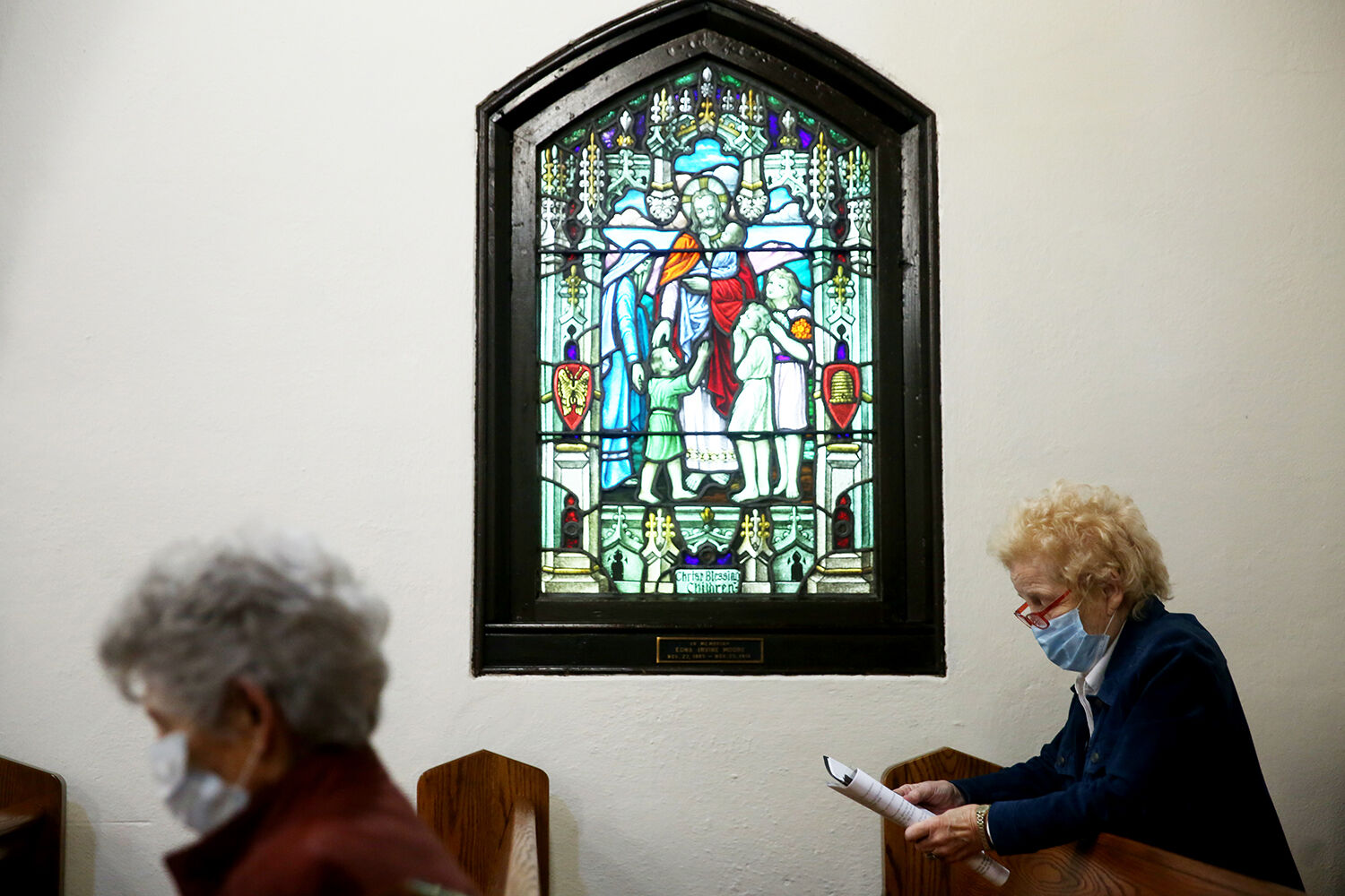 Mary Gammon, right, joins in a prayer with the other service attendees